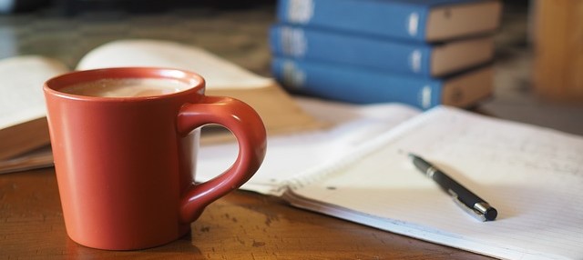 机の上の勉強用具とコーヒー